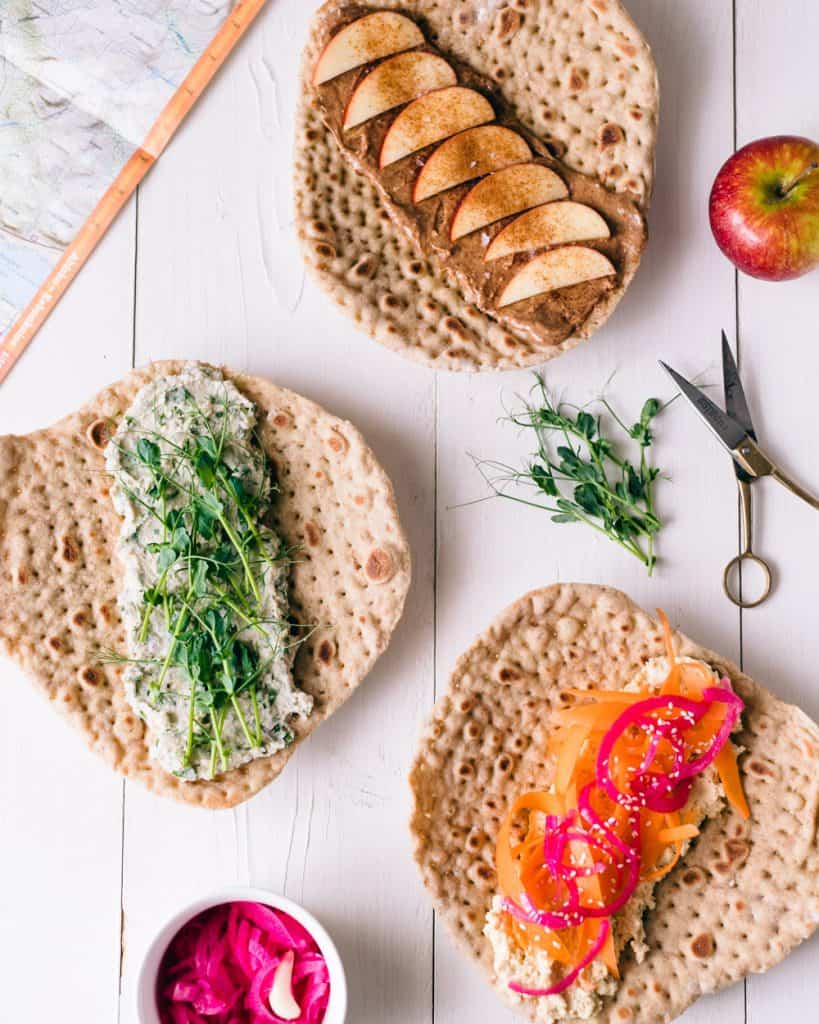 3 vegan sandwich wraps on a white table.