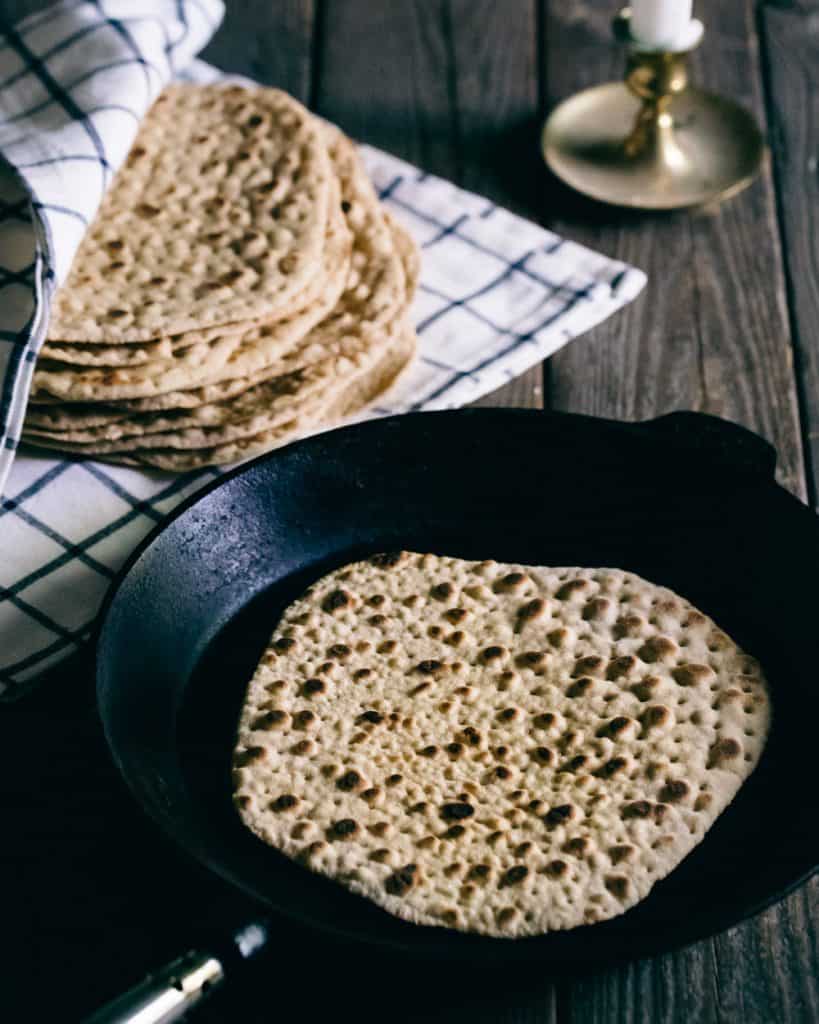 Flatbread in a pan on a wooden table.
