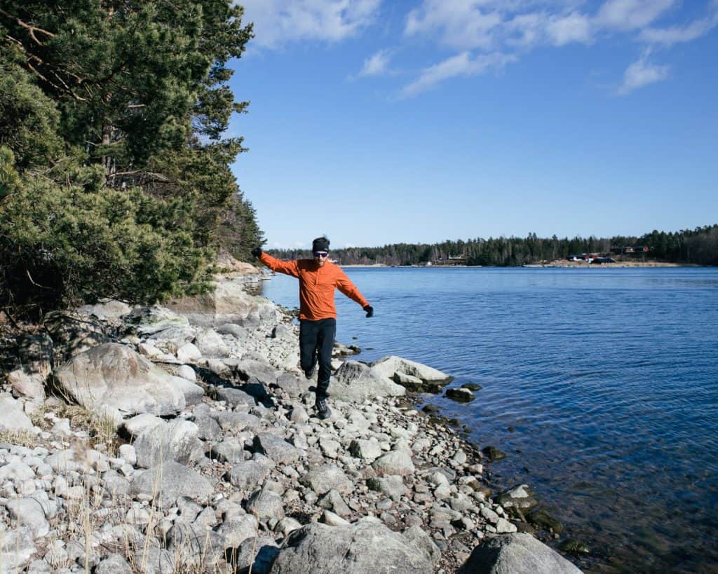 Man running along a rocky coastline in Sweden.