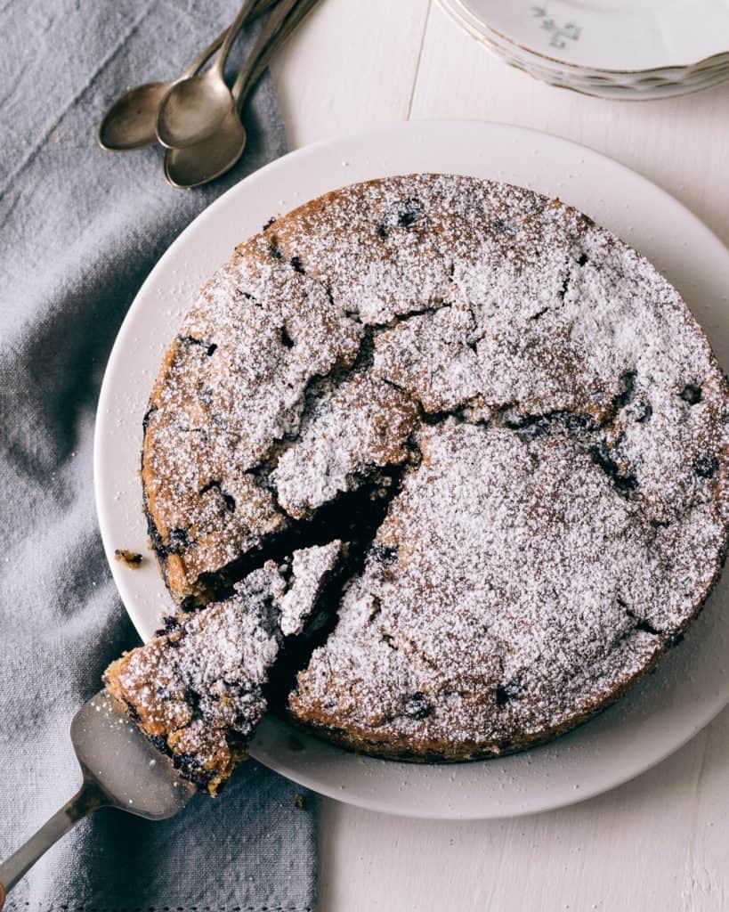 Blåbärskaka med florsocker på ett bord.